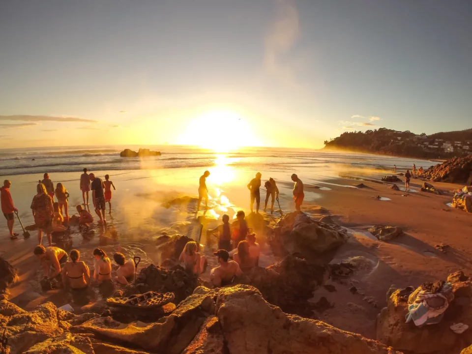 groupe de personnes a hot water beach regardant coucher de soleil